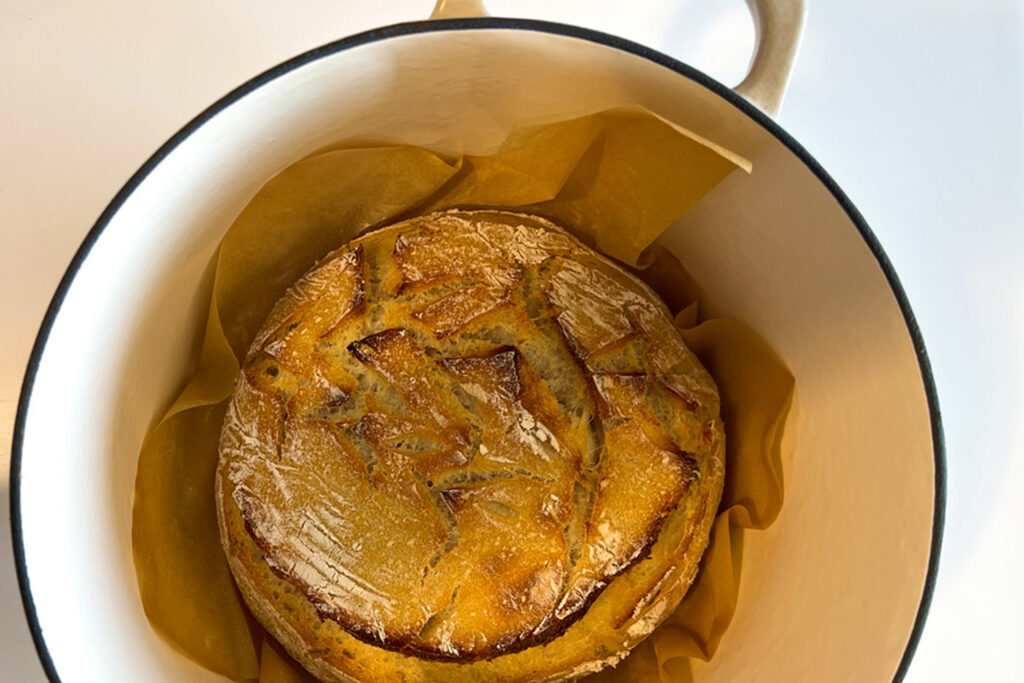 a loaf of sourdough bread in a Dutch Oven