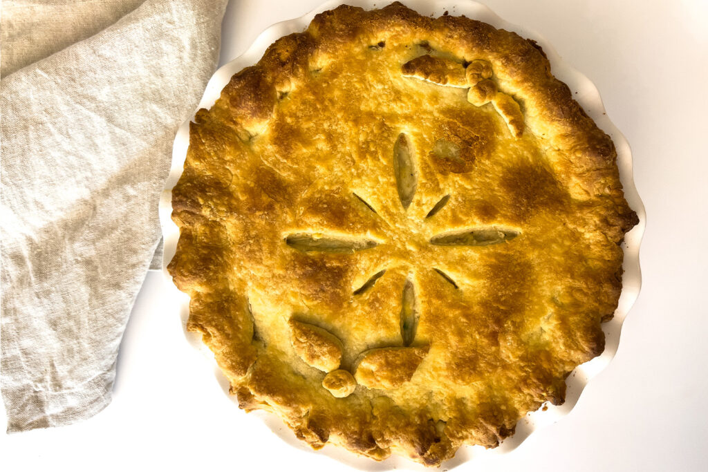 a cooked pie sits on the kitchen counter next to a linen cloth