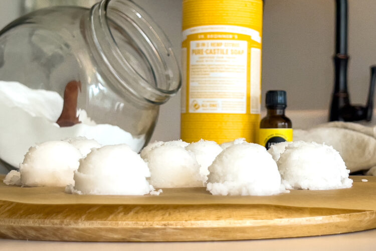 a tray of diy garbage disposal cleaner pods sits on the counter next to Castile soap and essential oils