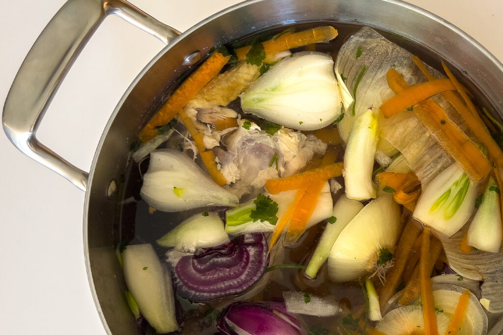 a pot of bone broth ingredients is sitting in a stockpot