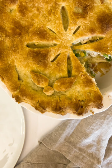 a slice of sourdough chicken pot pie sits next to the rest of the pie