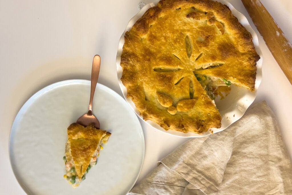 a slice of sourdough chicken pot pie sits next to the rest of the pie