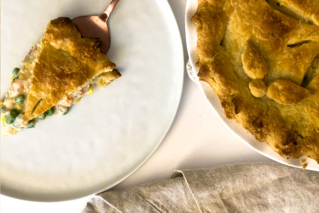 a slice of sourdough chicken pot pie sits next to the rest of the pie