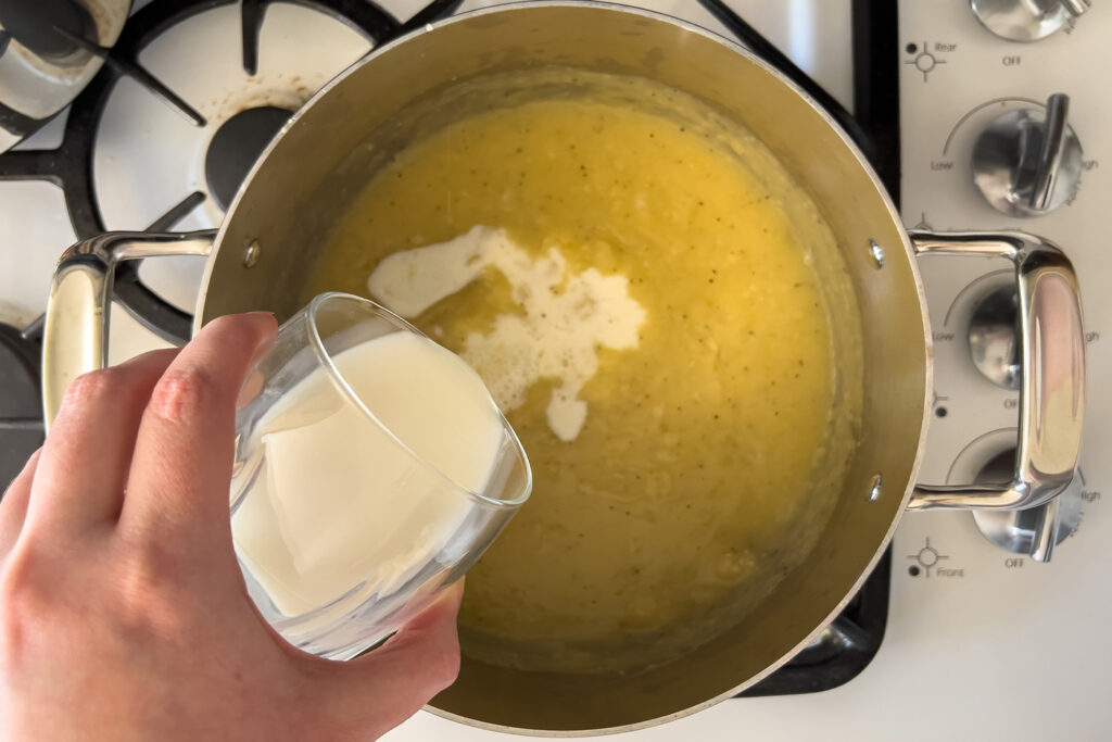 a woman is pouring milk into in a pot on the stove
