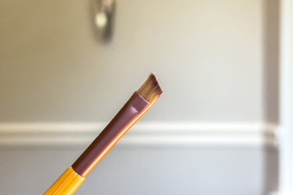 an angled makeup brush is being held