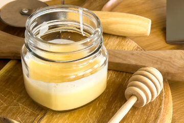 a jar of organic cutting board finish on a wood board with utensils