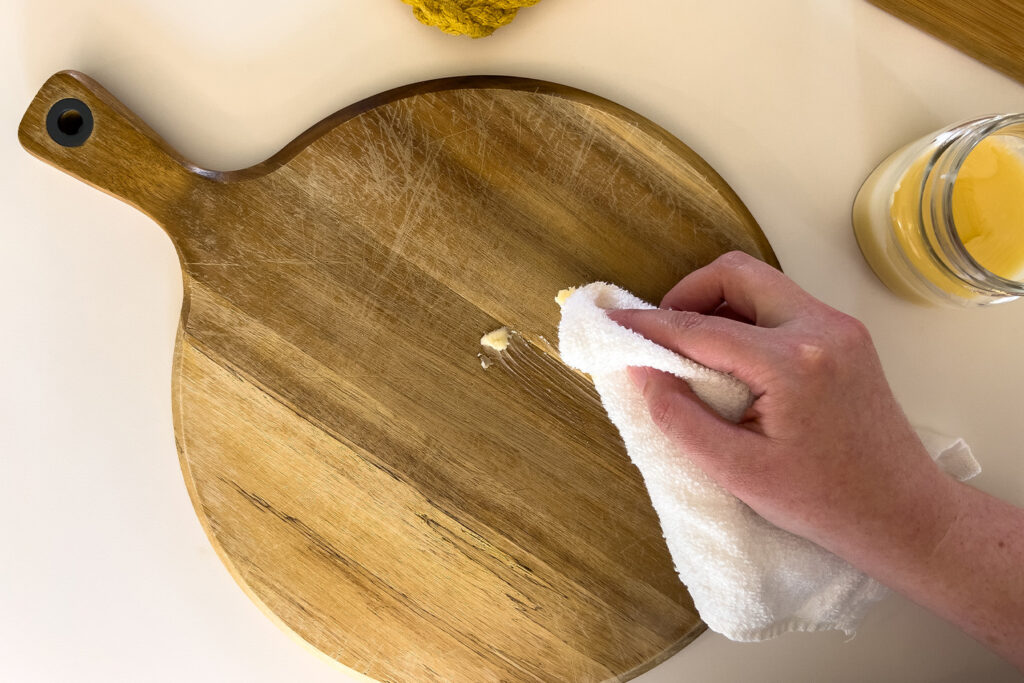 a woman applying organic cutting board finish to a cutting board