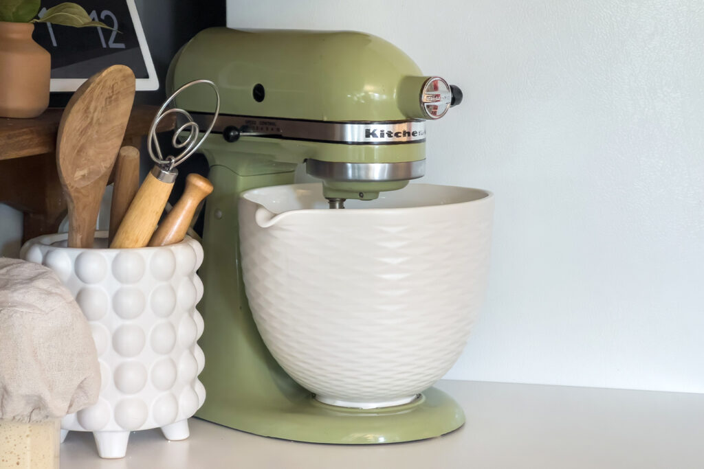 a vintage green kitchen aid mixer with a white ceramic bowl