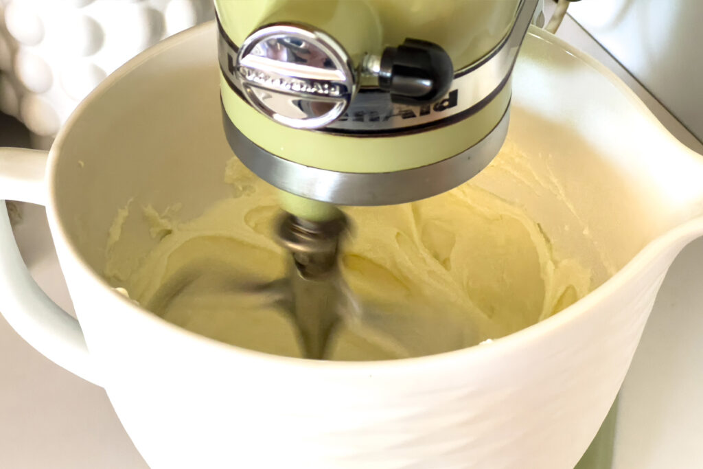 a stand mixer beating ricotta cheese and cream cheese
