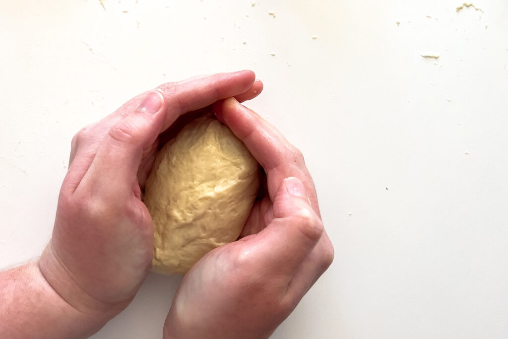 a woman cupping her hands around dough
