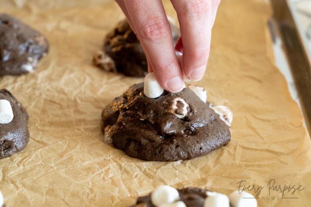 topping sourdough hot cocoa cookies with marshmallows halfway through baking