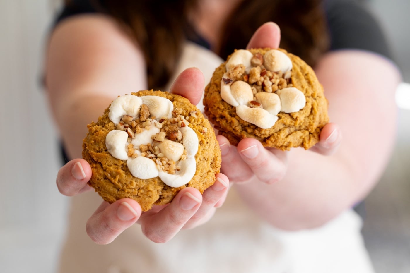 Marlene holding out two sourdough sweet potato casserole cookies toward the camera