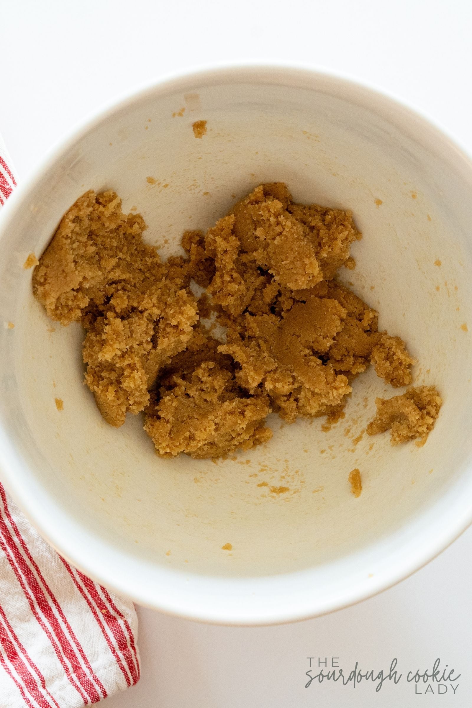 Creamed butter and brown sugar in a white mixing bowl for sourdough discard cookie dough.