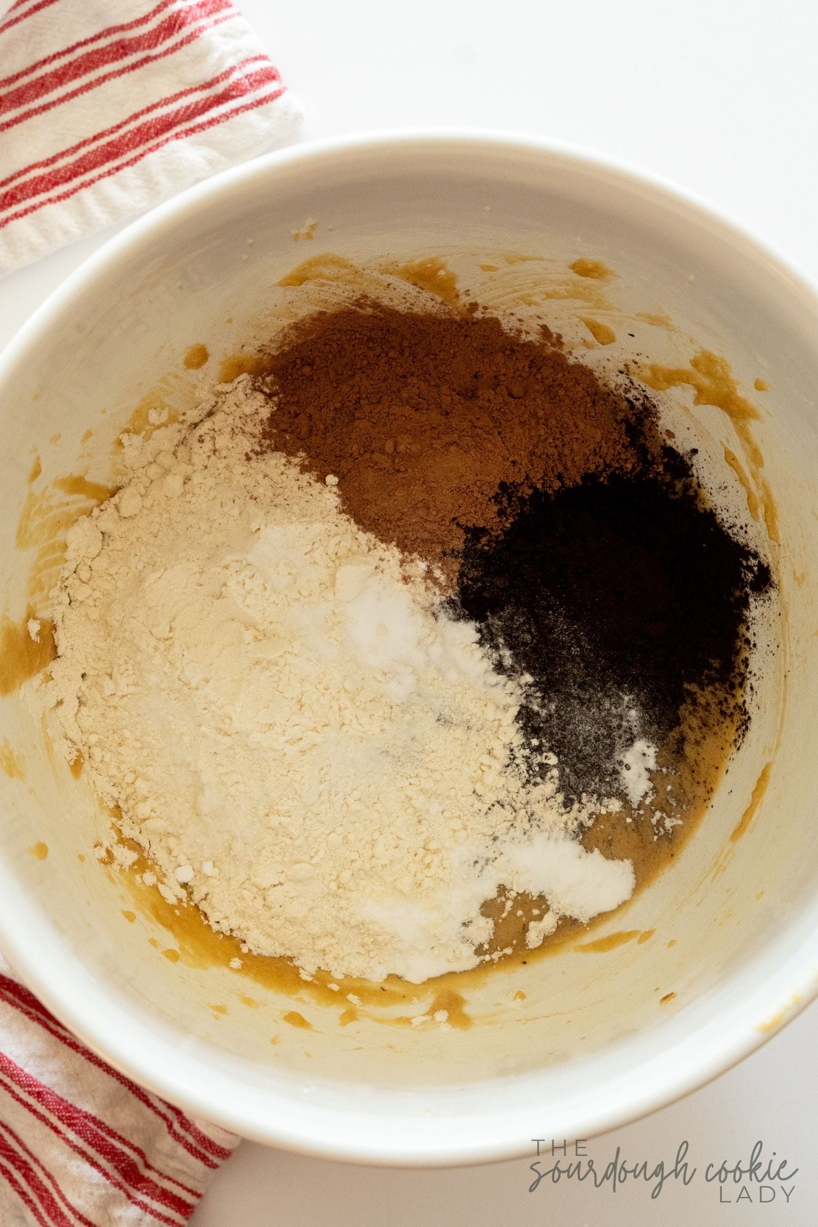 Flour, cocoa powder, and baking soda added to the creamed dough for sourdough peppermint hot cocoa cookies.